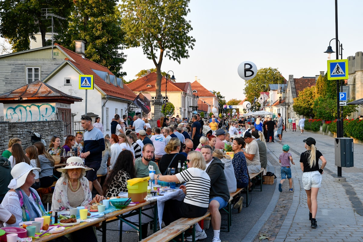 Gäste feiern gemeinsam an langen Tischen im Freien